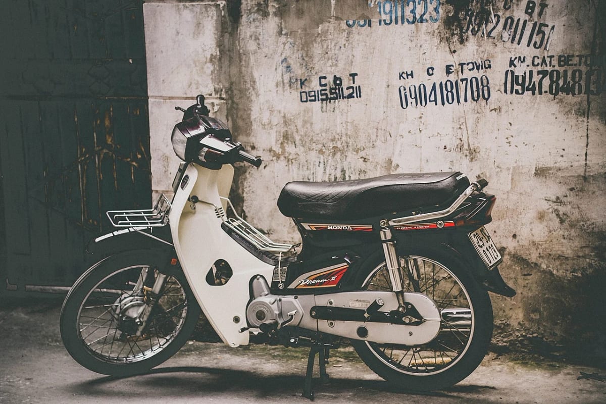 Petite moto Honda garée contre un mur de béton patiné, au Vietnam